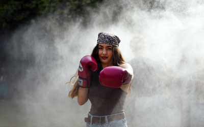 Portrait de Jeanne, championne du monde de muay thai, à travers la brume des brumisateurs du square Maurice Gardette.