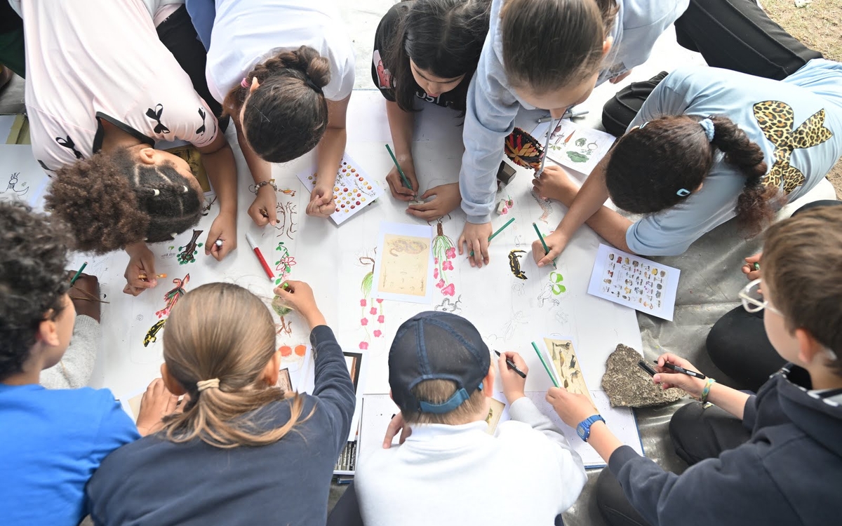 des enfants produisent une fresque collective en dessins