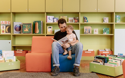 Un papa lit un livre à son jeune enfant