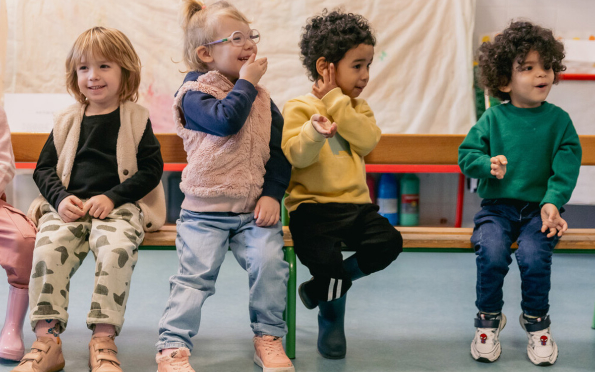 Enfants sur un banc dans une classe de maternelle
