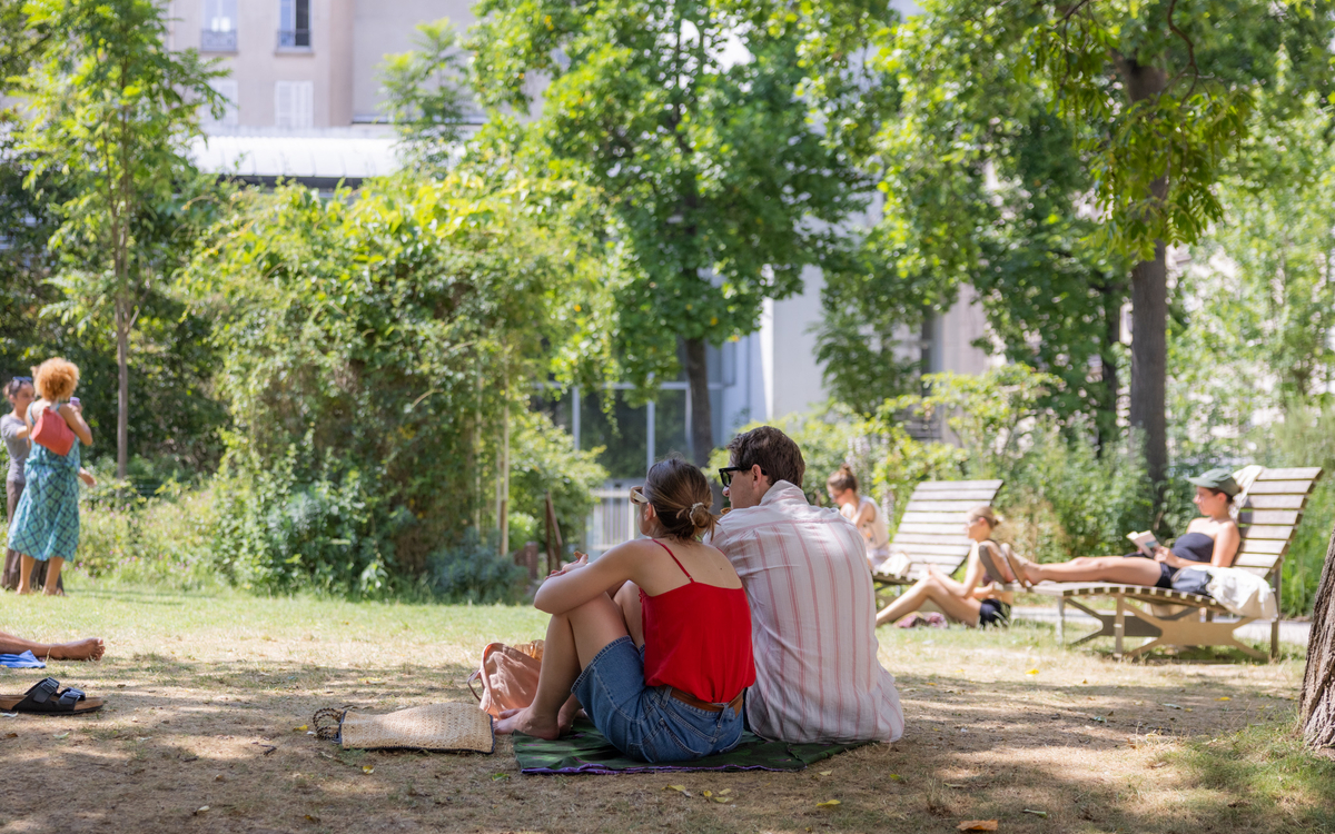 Un couple assis dans les pelouses du square Léon Serpollet dans le 18e