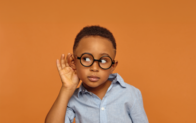 Un petit garçon à lunettes tend l'oreille