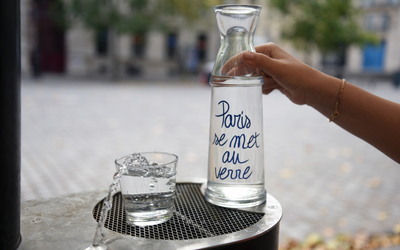 Carafe Paris se met au verre, prise en photo près d'une fontaine à eau de Paris.