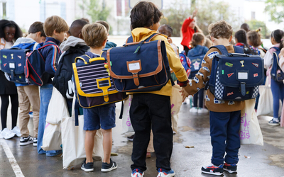 Un groupe d'enfant porte des cartables pour la rentrée scolaire