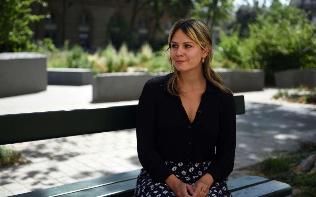 Portrait de Lily Munson déléguée générale au design, assise sur un banc Davioud. 
