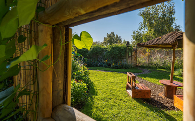 vue sur le jardin à travers une fenêtre de cabane en bois