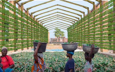 Photographie d'Ibrahim Mahama représentant des personnes avec des seaux sur la tête remplis de bouteilles de verres