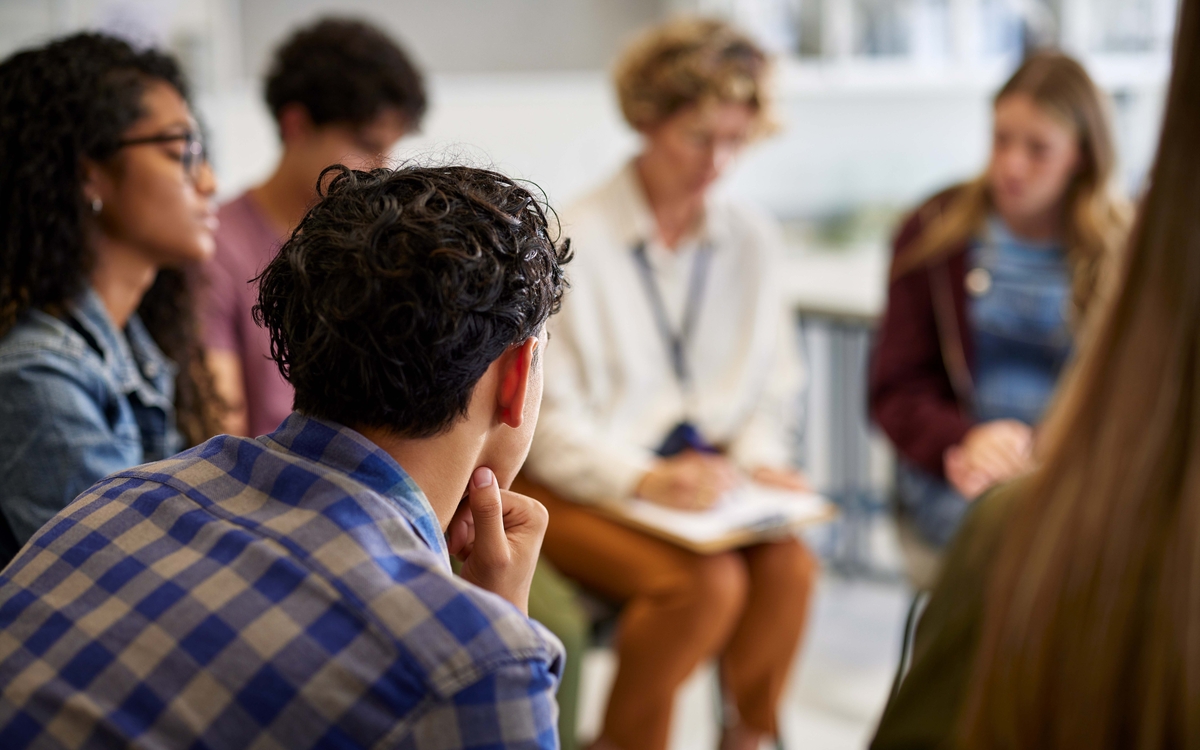 Groupe de jeunes en cercle autour d'une thérapeute