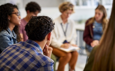 Groupe de jeunes en cercle autour d'une thérapeute