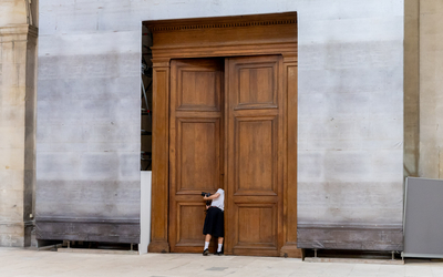 Une personne ouvre une porte et jette un oeil curieux à la chapelle de la Sorbonne. 