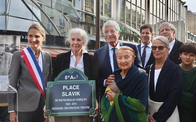Des femmes et des hommes entourant la plaque de rue au nom de Slavik