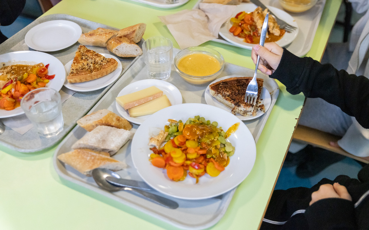 Une table de cantine scolaire avec des plateaux 