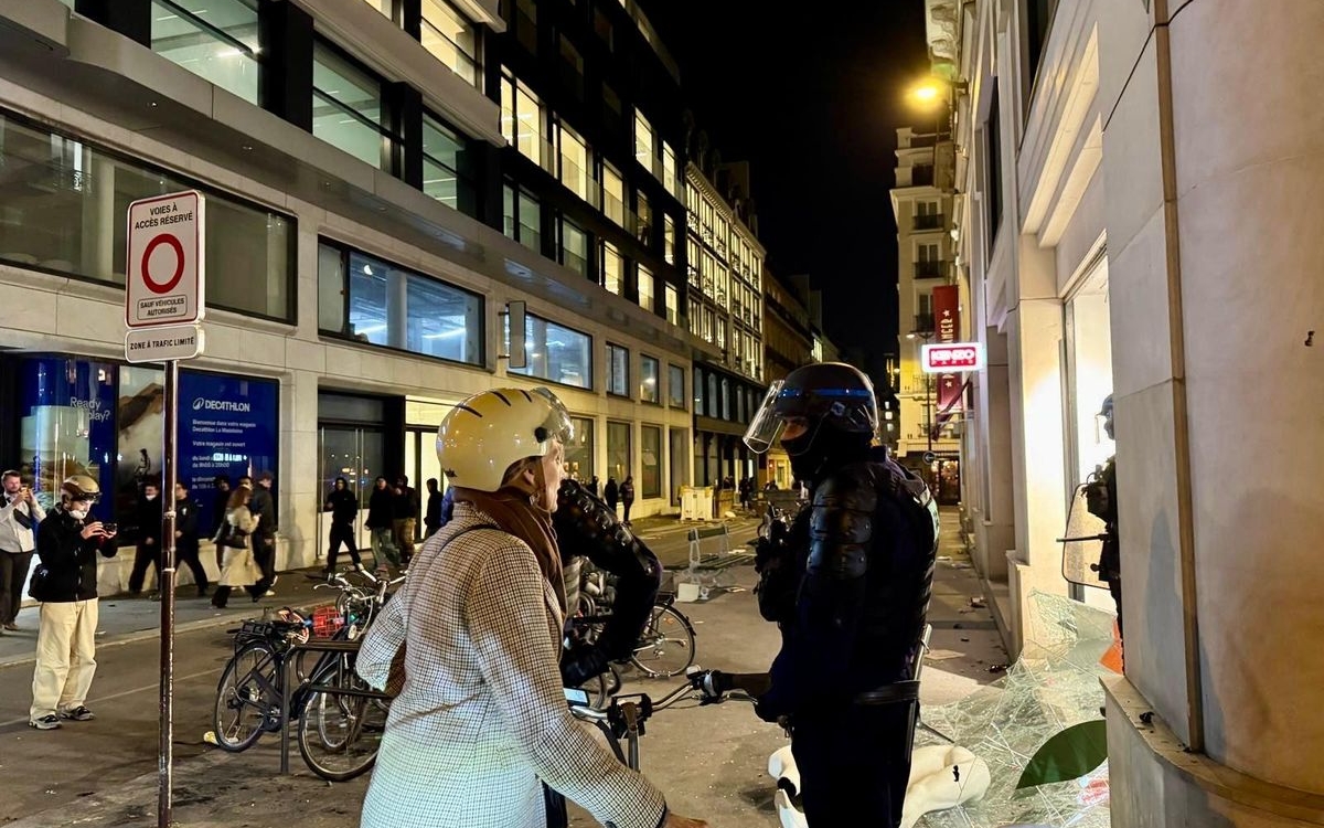 Une femme discutant avec un policier dans une rue de Paris en pleine nuit