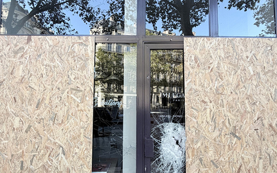 Vitrine d'un commerce cassée avec des planches en bois pour réparation