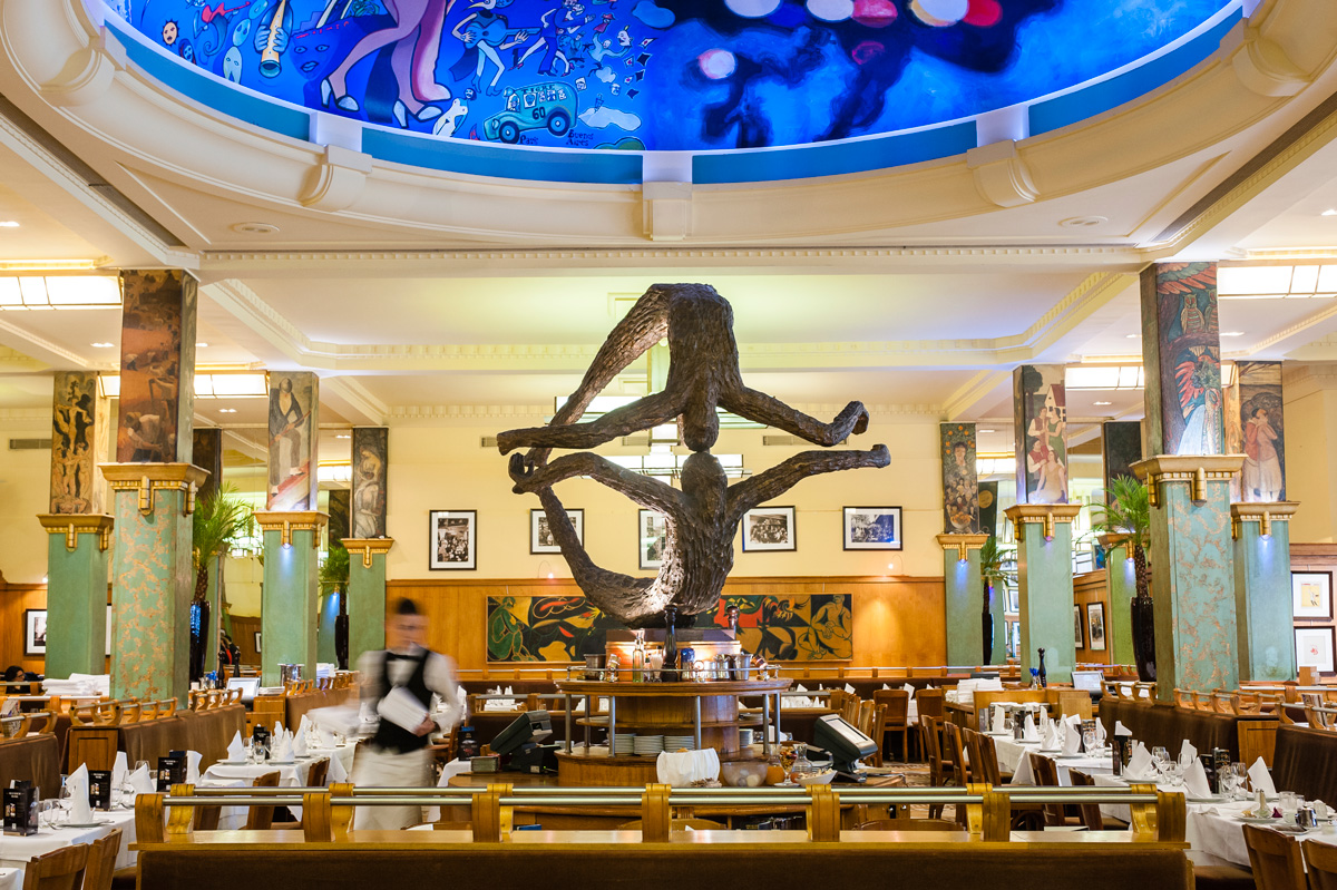 La Coupole est une brasserie ouverte en 1927 dans le quartier du Montparnasse qui fut un haut lieu du Tout-Paris dans l' entre-deux-guerres. Vingt-sept peintres ont réalisé des fresques Art Déco sur les piliers de la salle du rez-de-chaussée, inscrite aux (Emilie Chaix / Ville de Paris) La Coupole est une brasserie ouverte en 1927 dans le quartier du Montparnasse qui fut un haut lieu du Tout-Paris dans l' entre-deux-guerres. Vingt-sept peintres ont réalisé des fresques Art Déco sur les piliers de la salle du rez-de-chaussée, inscrite aux