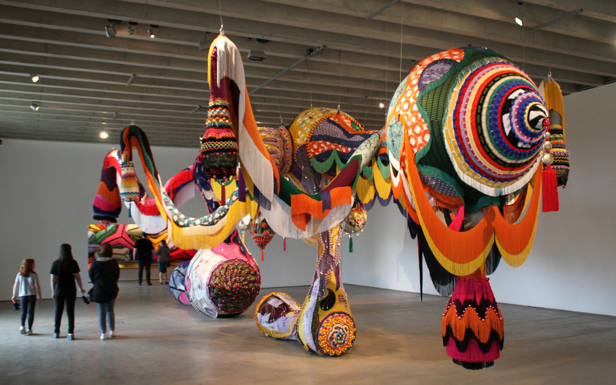 Photo d'une sculpture monumentale de Joana Vasconcelos intitulée Valkyrie Marina Rinaldi, faite d'éléments en crochet et tissus multicolores suspendus au plafond