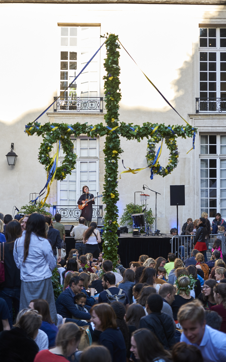 Photographie d'un concert avec en premier plan le mât fleuri de Midsommar 