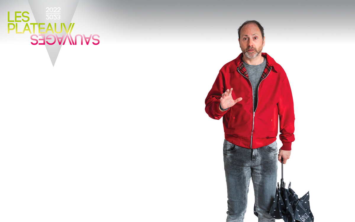 Un homme en pull rouge, les pieds devant un paillasson, tient un parapluie dans sa main.