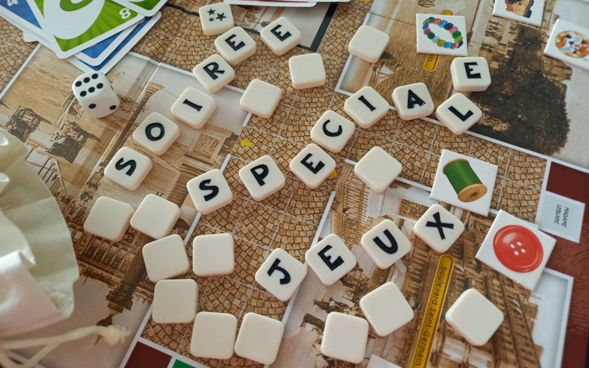 photographie de d'éléments de jeux dont des pièces de scrabble qui forment les mots "soirée spéciale jeux"