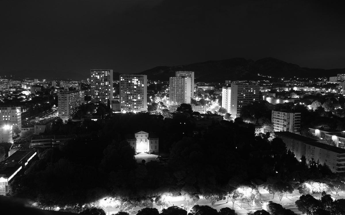 Photographie en noir et blanc d'une ville la nuit