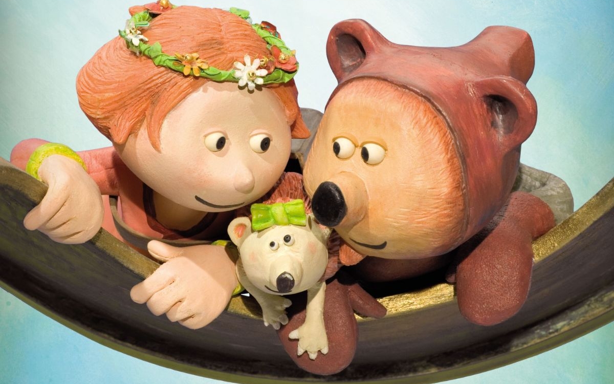 Une jeune fille, un ours et une souris ont l'air heureux.