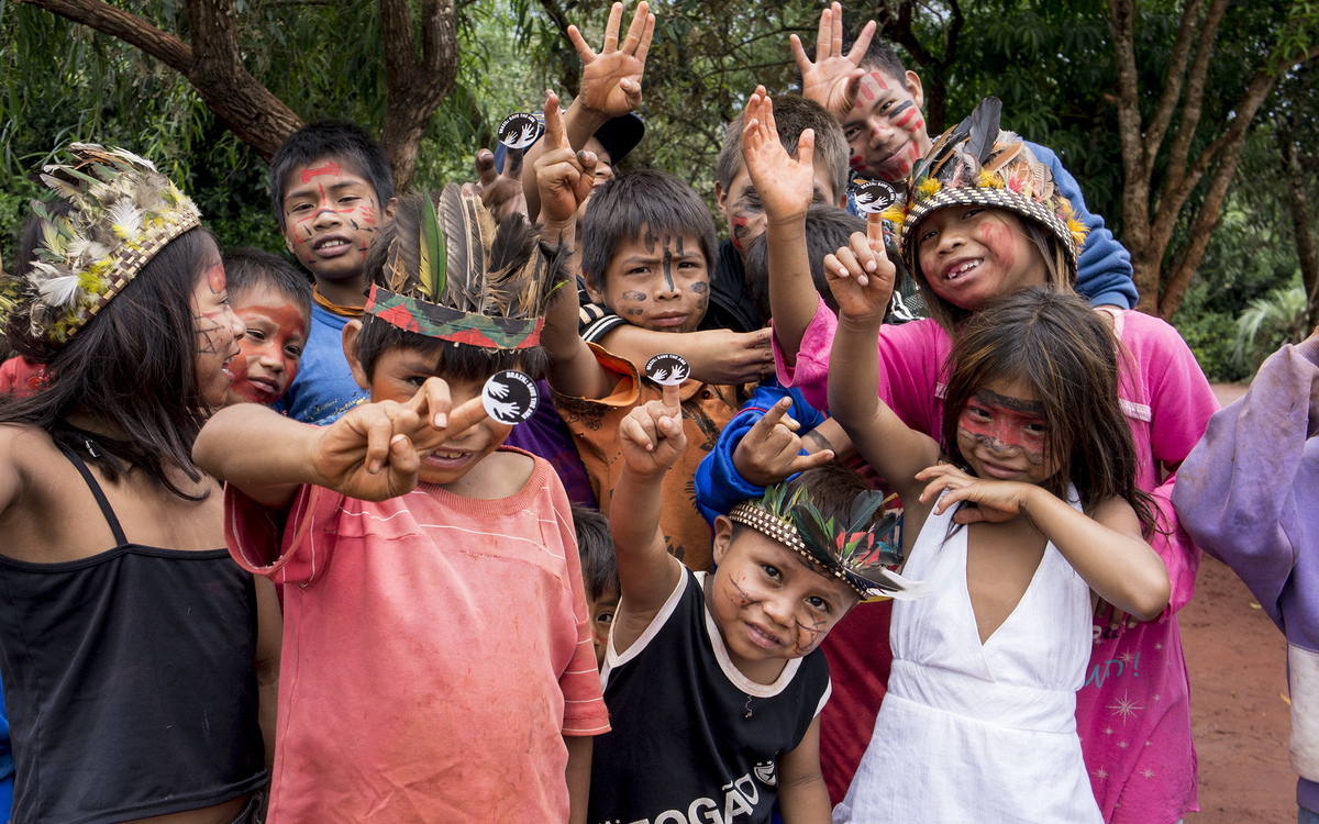 Enfants Guarani avec l'autocollant Awáicon. L'Awáicon a été utilisé dans le monde entier pour exprimer le soutien aux Awá.