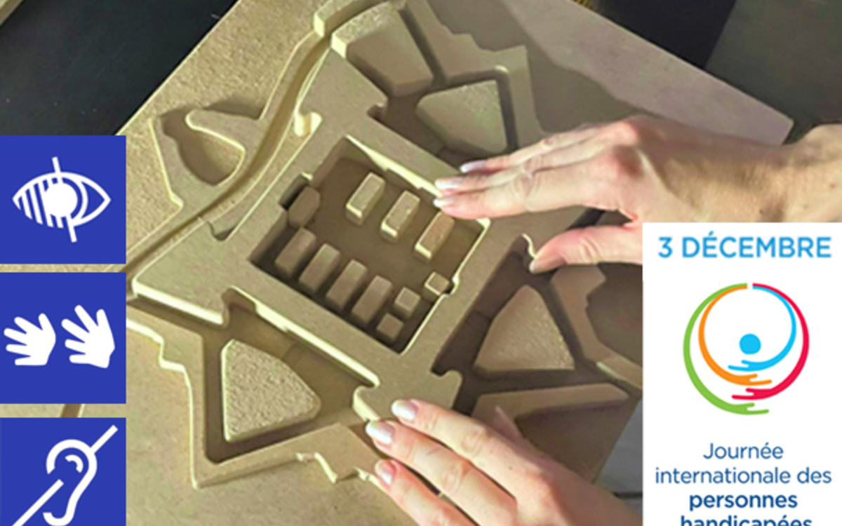 Deux mains touchent une maquette tactile en bois clair représentant une citadelle.