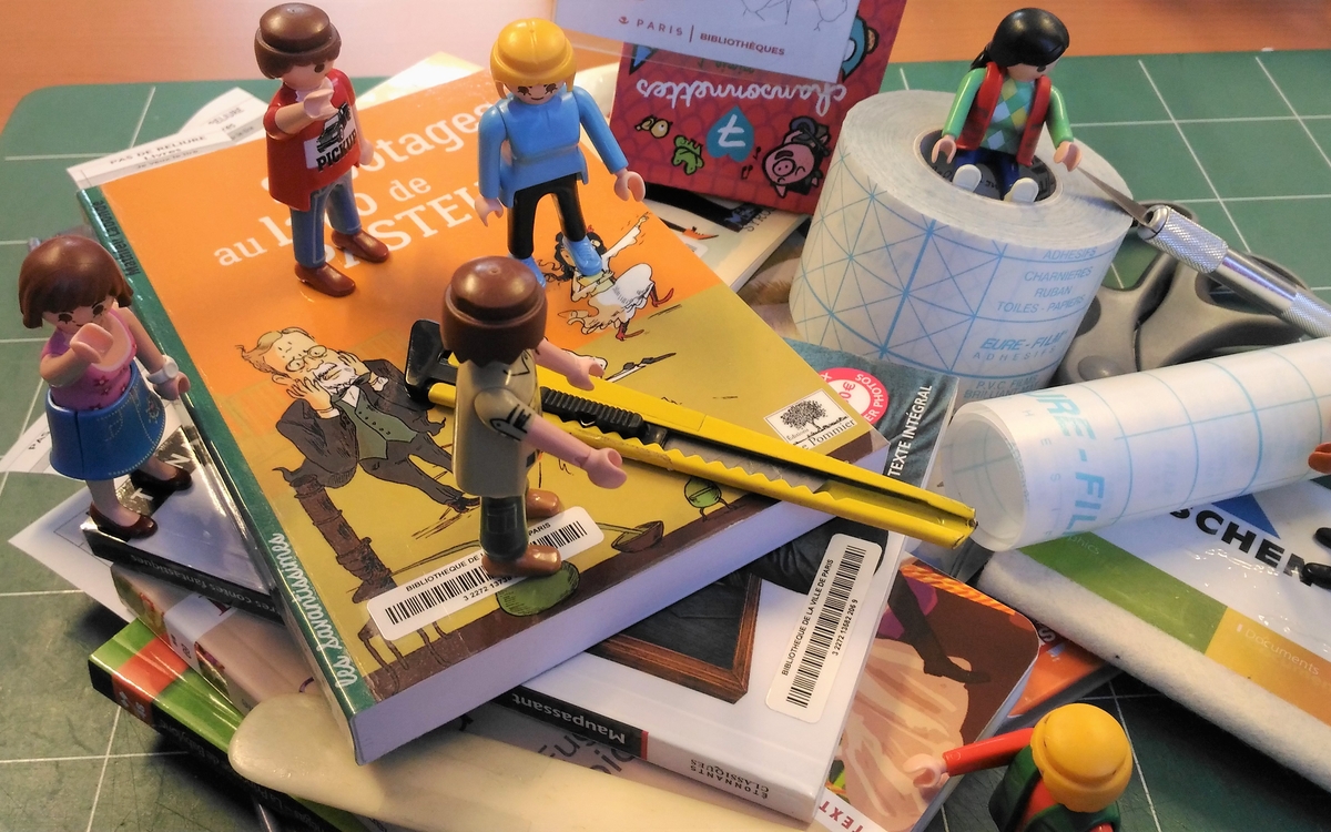 playmobils réparant des livres