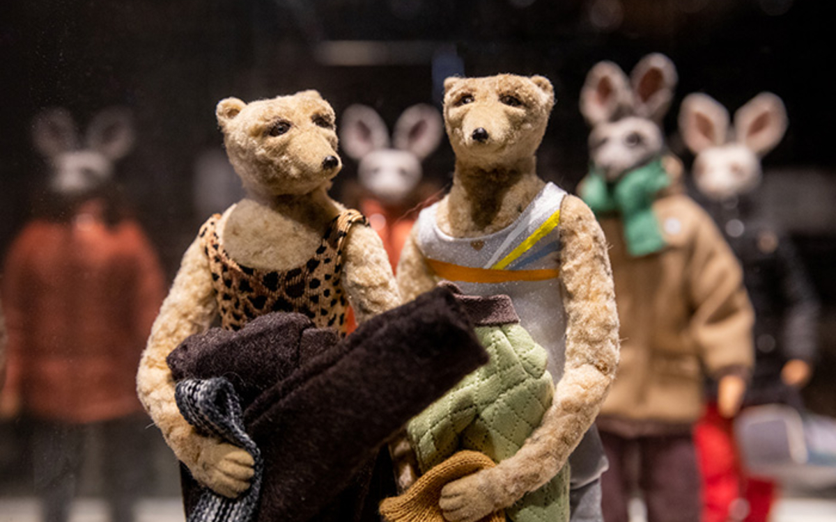 File de petites figurines représentant des animaux mais vêtues comme des êtres humains.