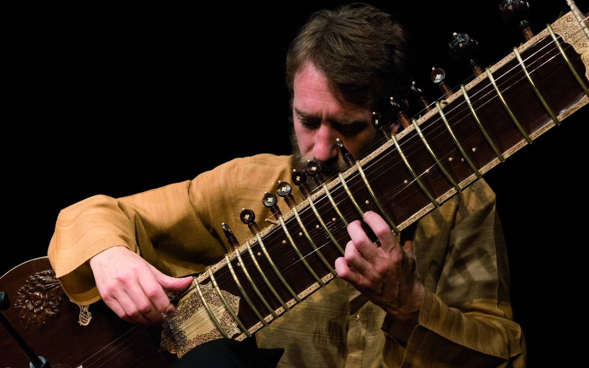 Nicolas Delaigue jouant d'un instrument de musique indienne