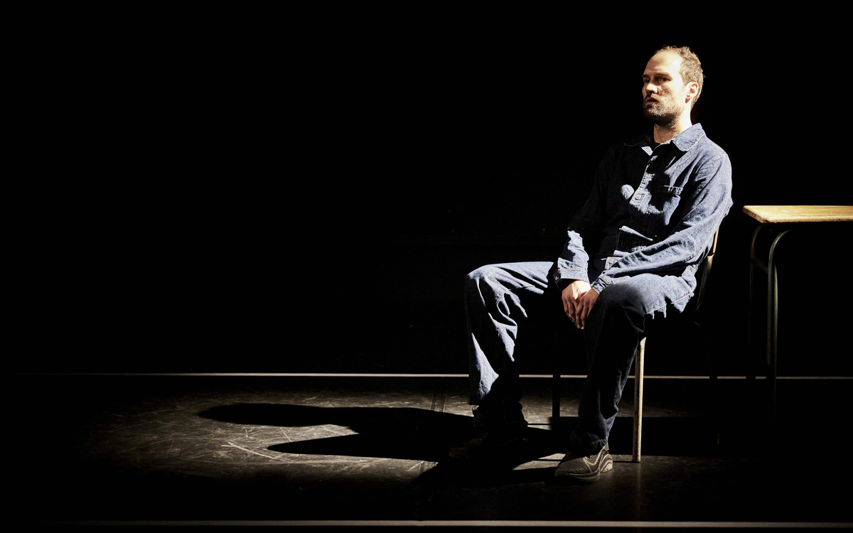 Comédien, assis, seul en scène