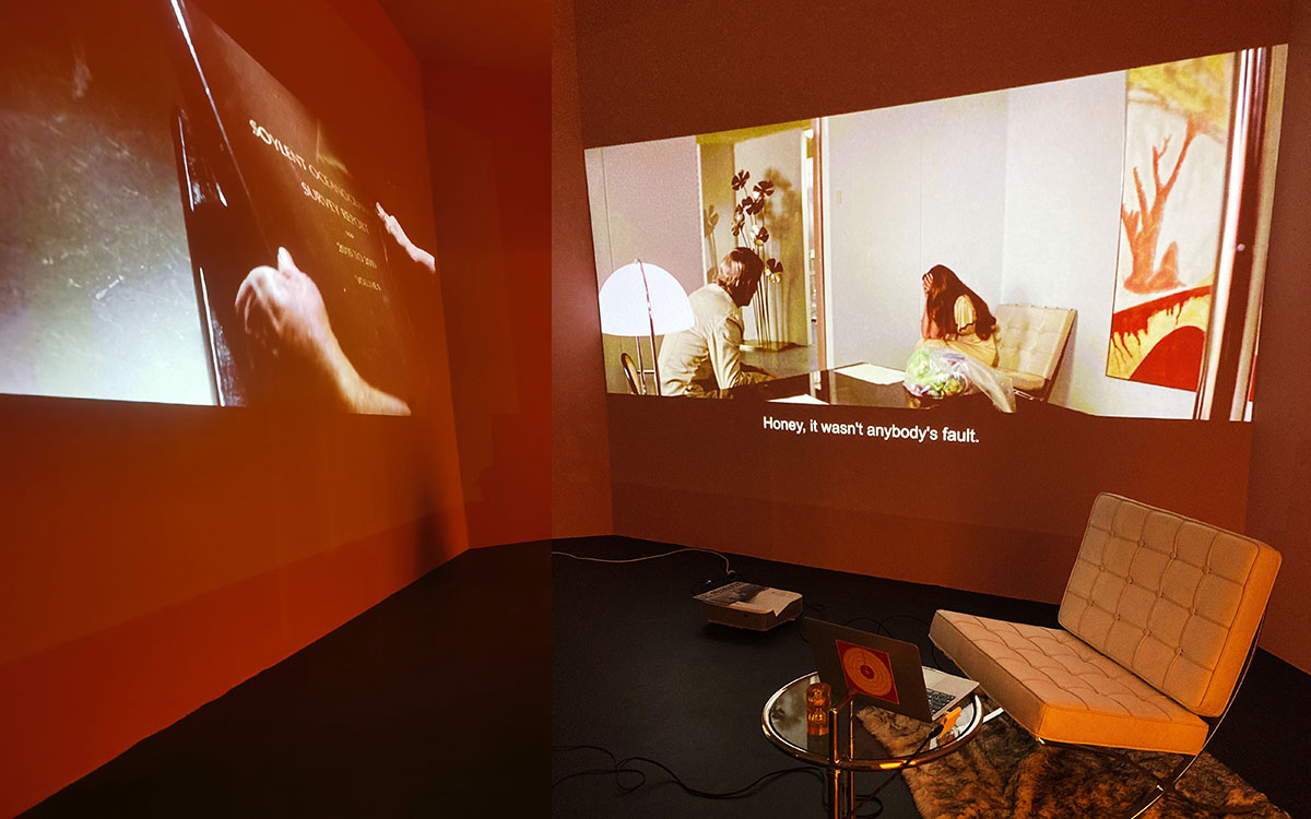 Installation montrant un salon constitué de mobilier moderne et des films projetés sur écran