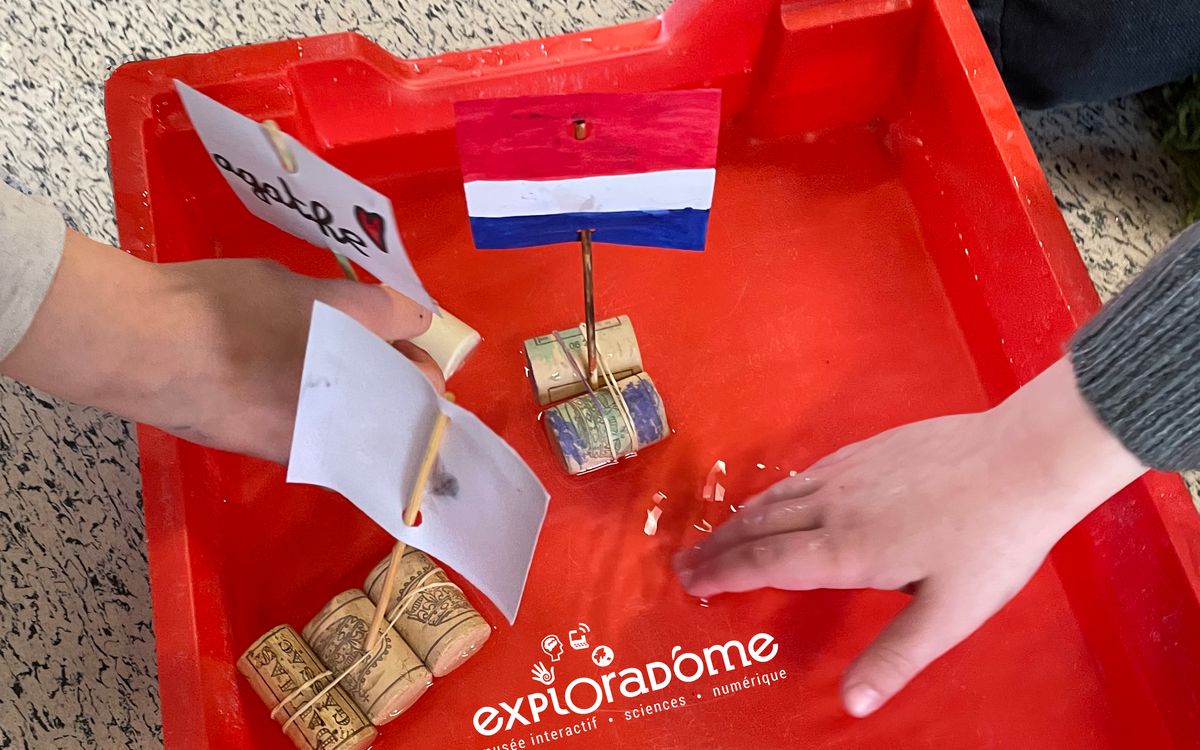 Un groupe d'enfants mettant à l'eau leurs radeaux.