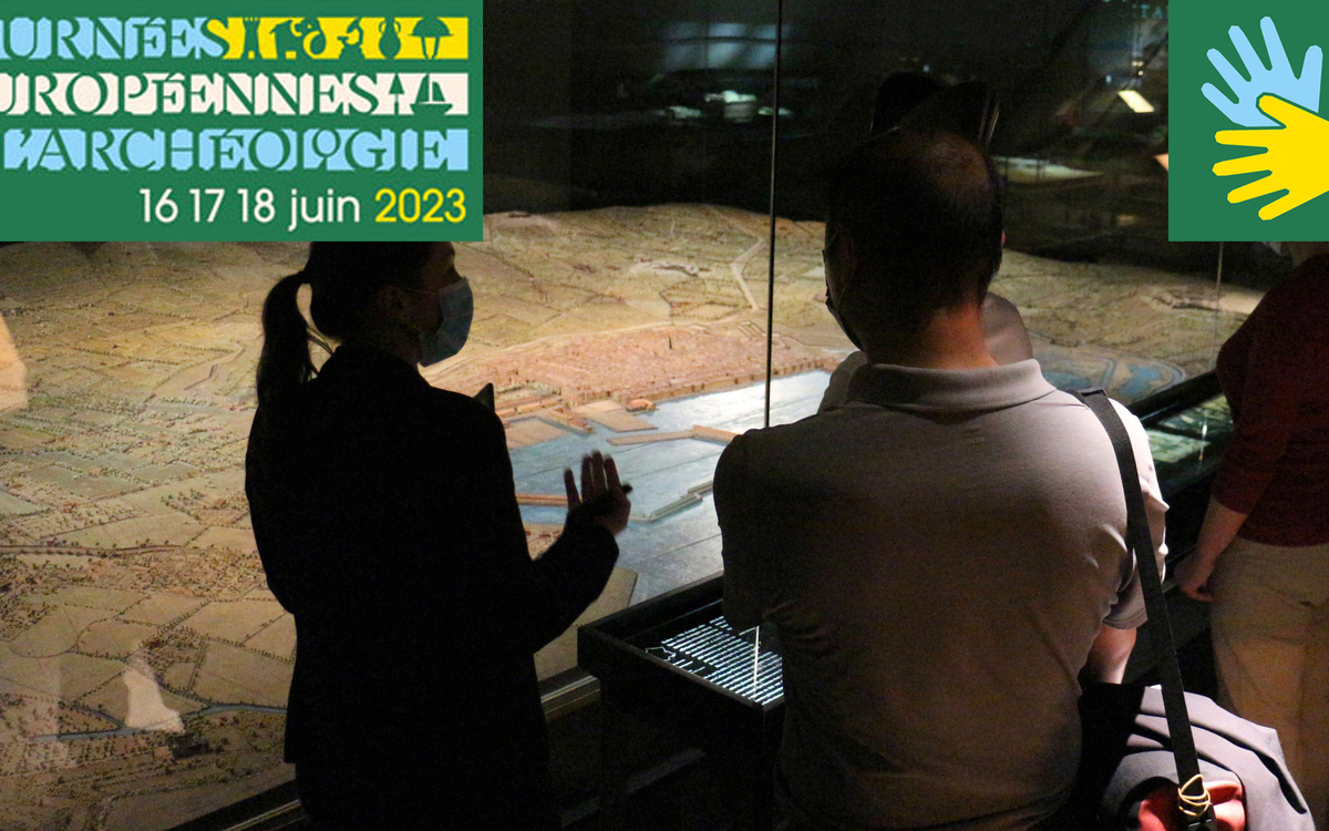 Vue de la maquette de Toulon avec des ombres de visiteurs et d'une guide devant. Ont été rajoutés sur la photo le logo de la langue de signes (deux mains) et le logo des Journées de l'archéologie.