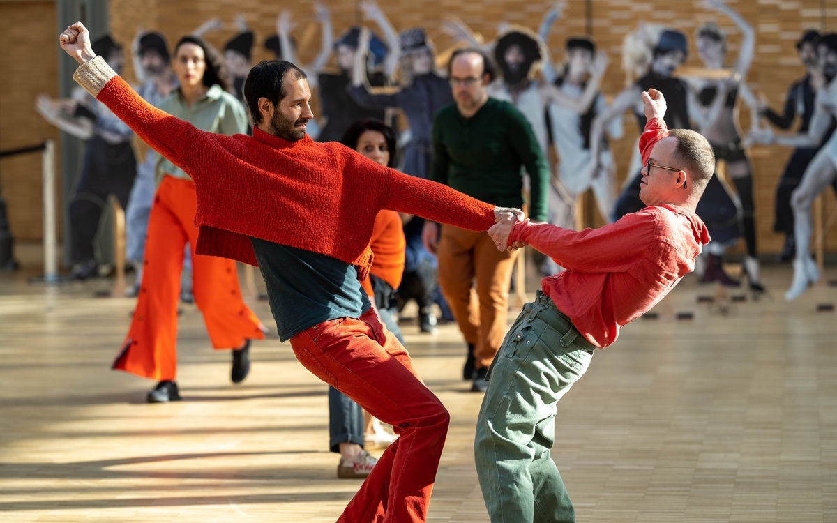 Deux danseurs poings levés se tiennent la main, au don des silhouettes 