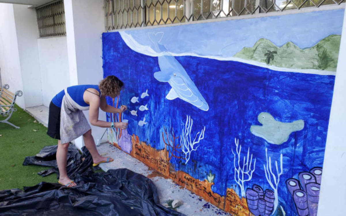 Anne Defréville peignant sur fresque 