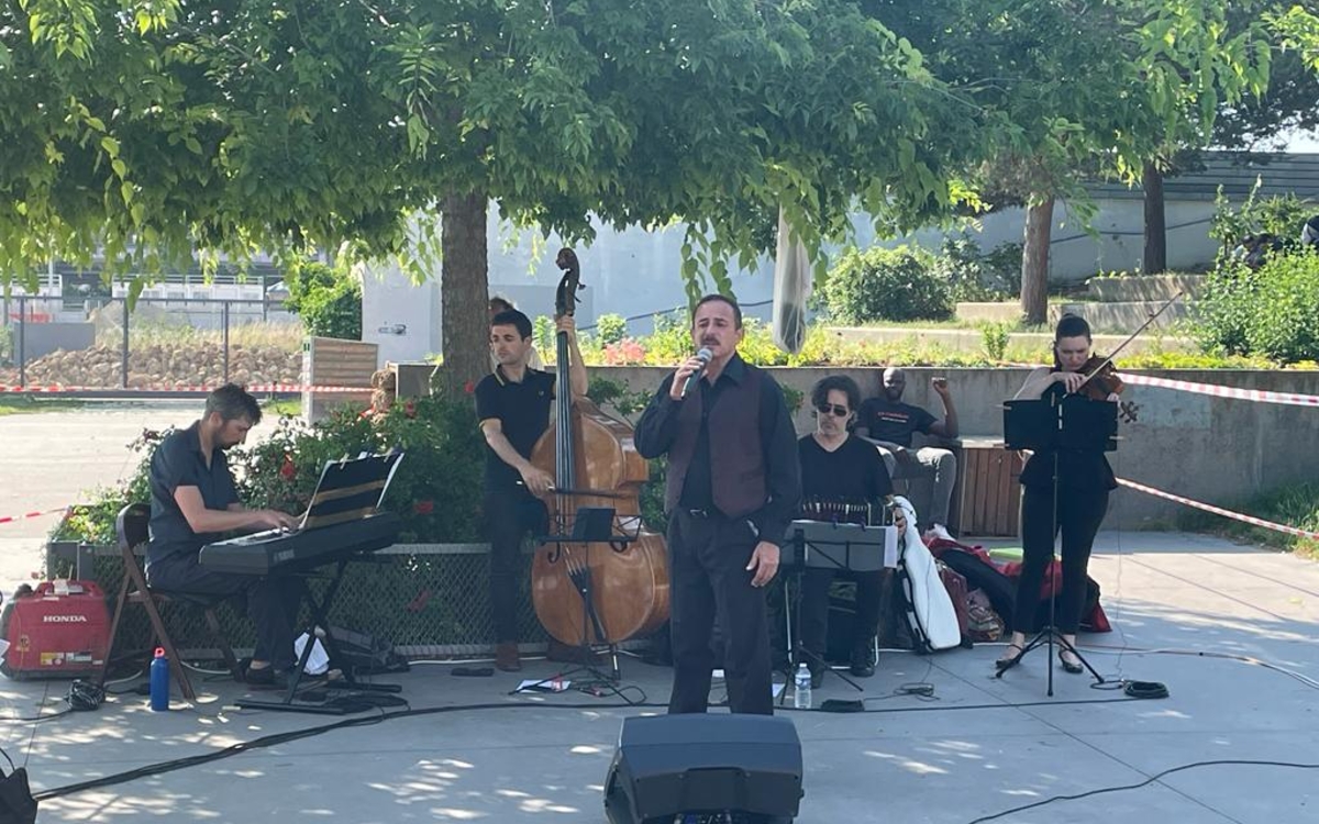 Concert de tango l'été, gratuit, devant un parc avec du public au premier plan, dans le 18ème arrondissement de Paris
