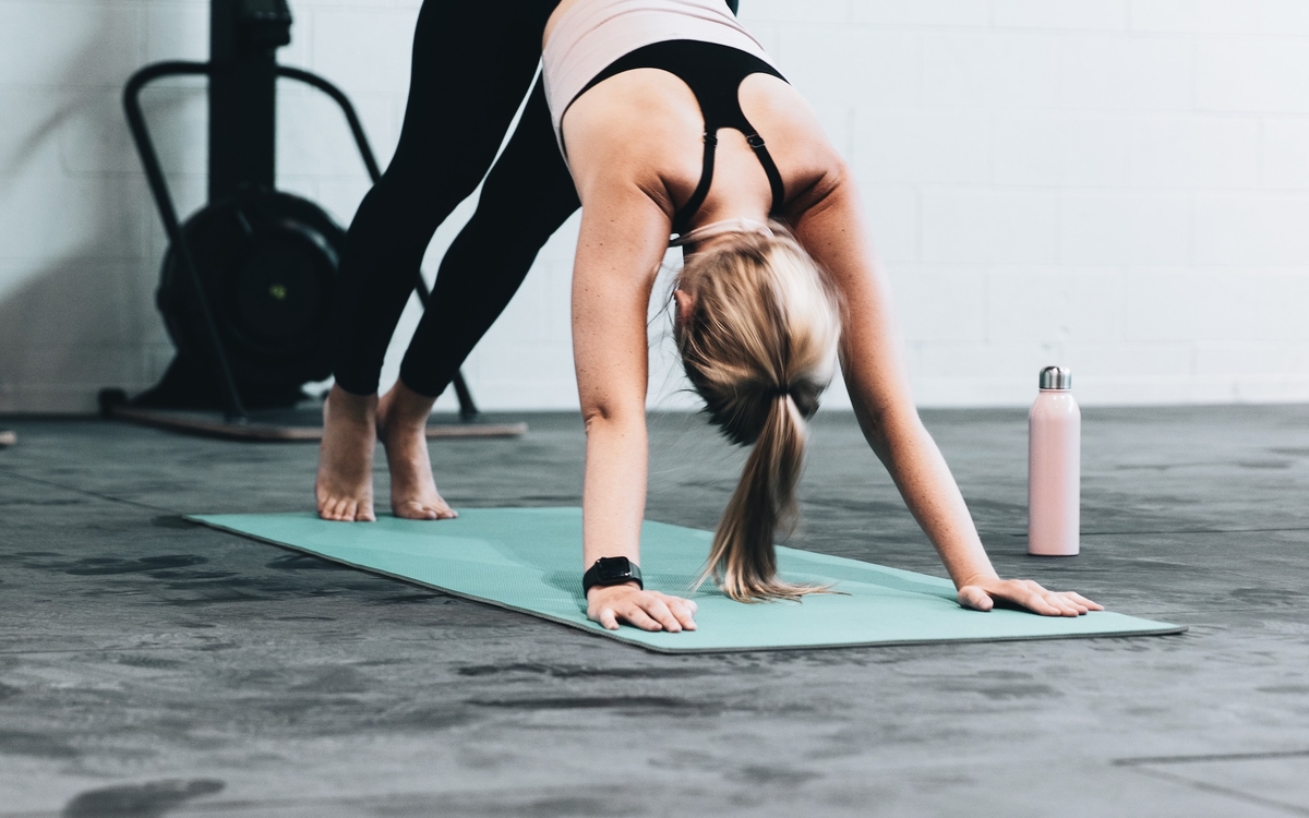 Femme s'étirant sur un tapis de yoga
