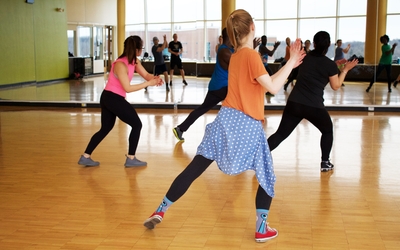 Femmes de dos dans une salle de sport, dansant la Zumba