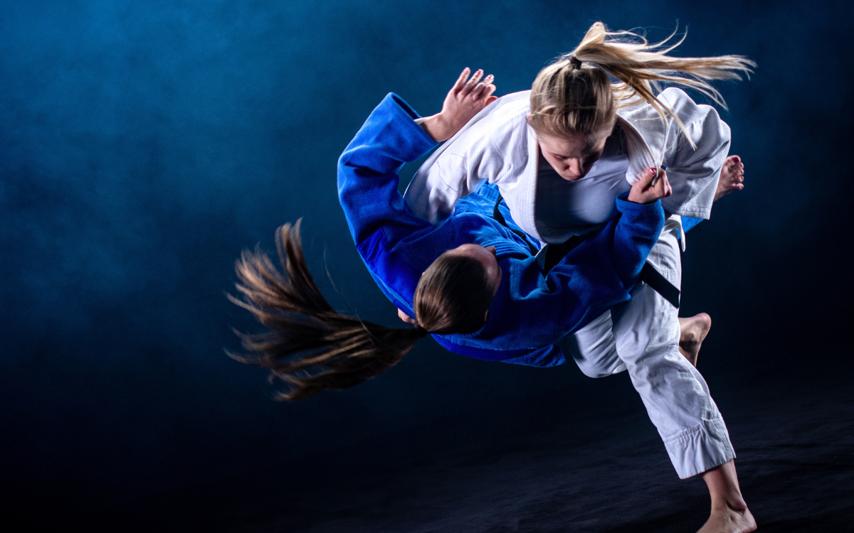 deux femmes faisant une prise de judo de domination