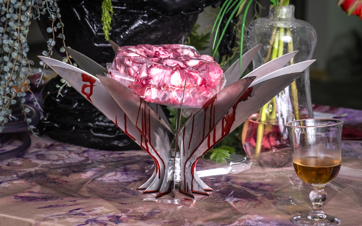 Une table présentant des objets d'art de la table aux couleurs et aux formes extravagantes et à la connotation inquiétante : couteaux aiguisés, sang...