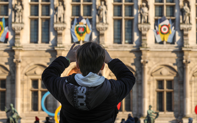 Enfant prenant une photo de la façade de l'Hôtel de Ville 