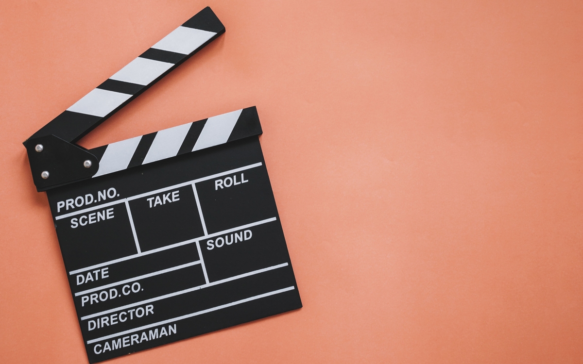Clap de tournage cinématographique, sur un fond orange