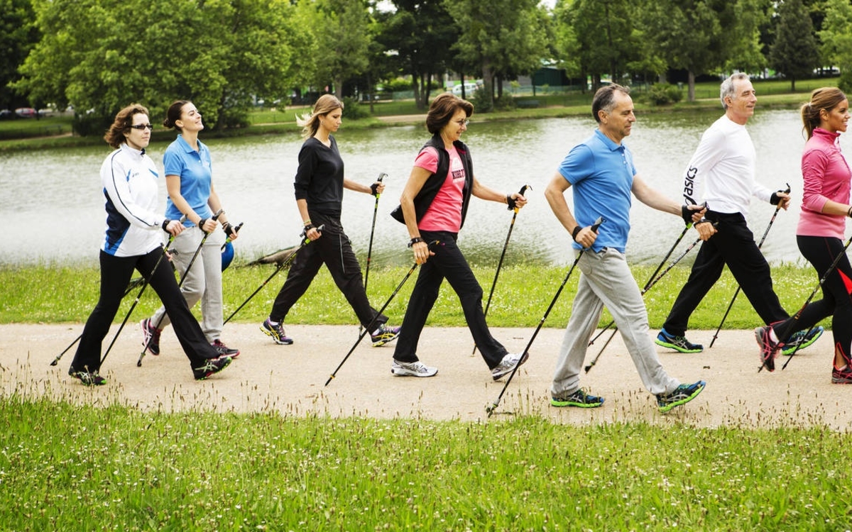 Petit groupe de marche nordique au bors d'un lac
