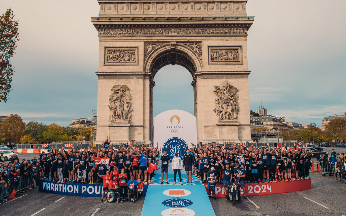 Eliud Kipchoge posant devant l'Arc de Triomphe à l'occasion des j-1000 du marathon pour tous de Paris 2024