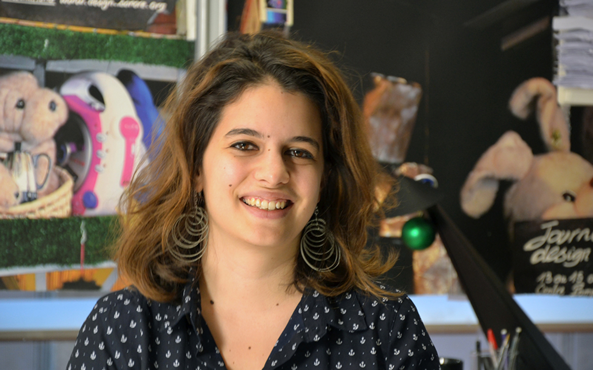 Photo de la chercheuse Alice Cohen-Hadria,  jeune femme souriante, au cheveux longs bruns avec des reflets miel. Elle porte une chemis à pois et des grandes boucles d'oreilles circulaires argentées