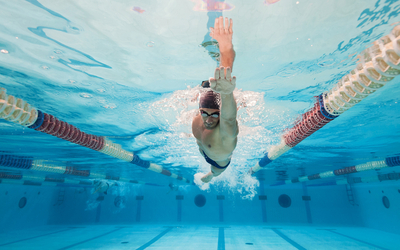 Un nageur pratique le crawl dans une piscine. 