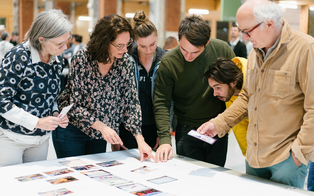 Plusieurs personnes discutent autour d'une fresque du climat