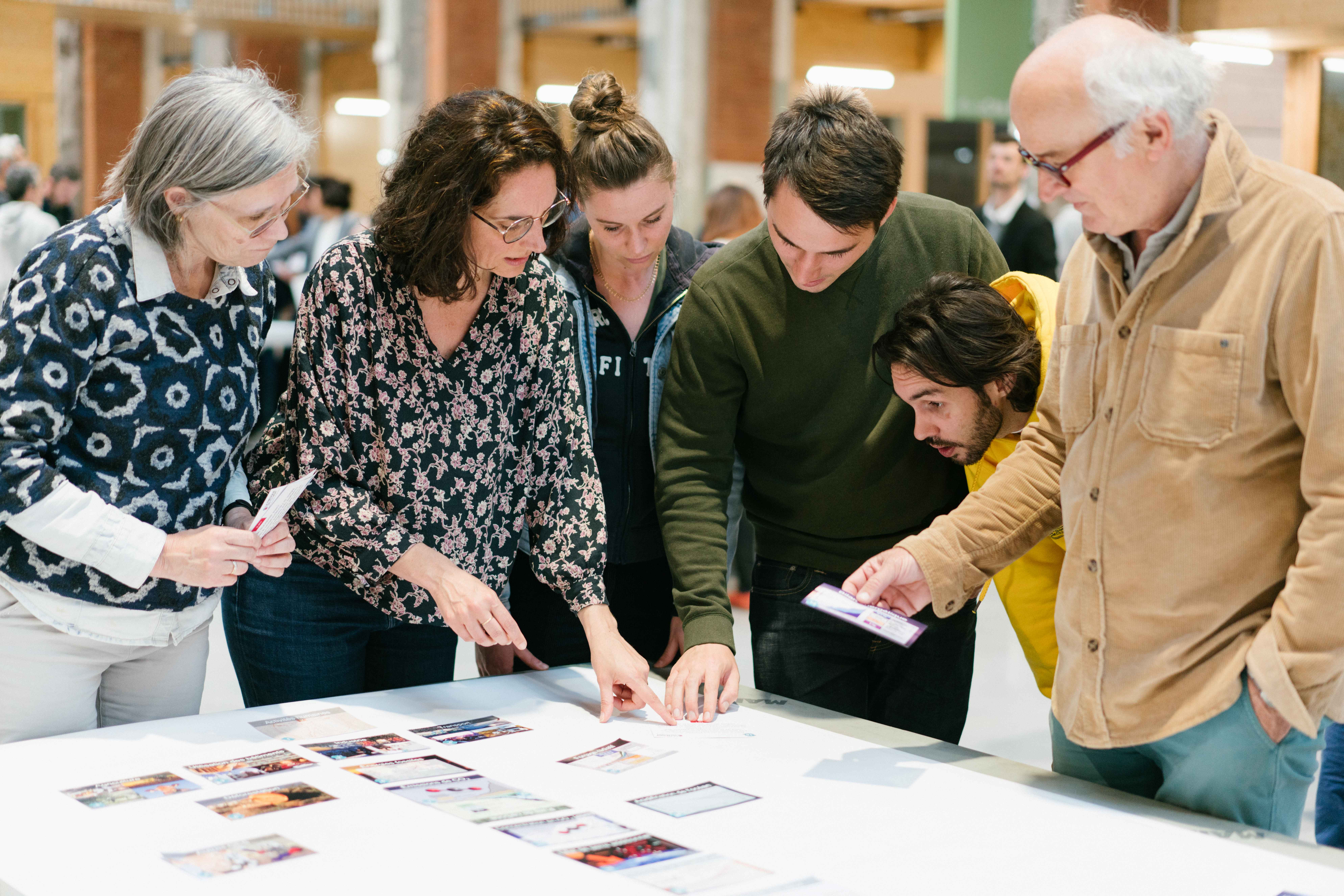 Plusieurs personnes discutent autour d'une fresque du climat