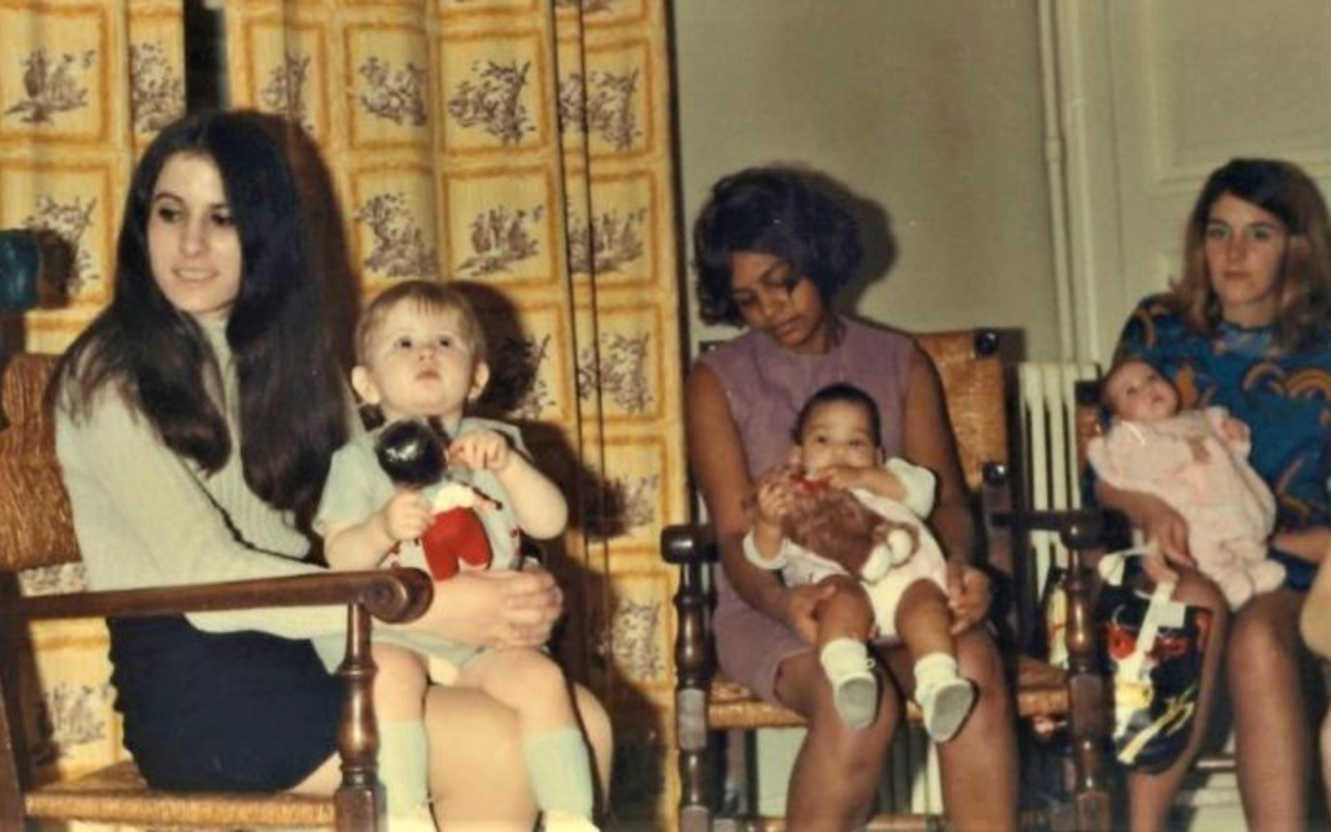 Plusieurs femmes assises tenant des bébés et enfants sur leurs genoux